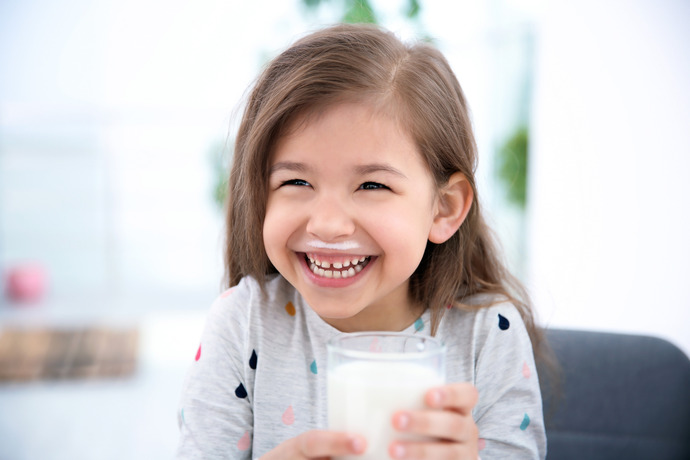 iña alegre por beber leche y disfrutar de sus beneficios.