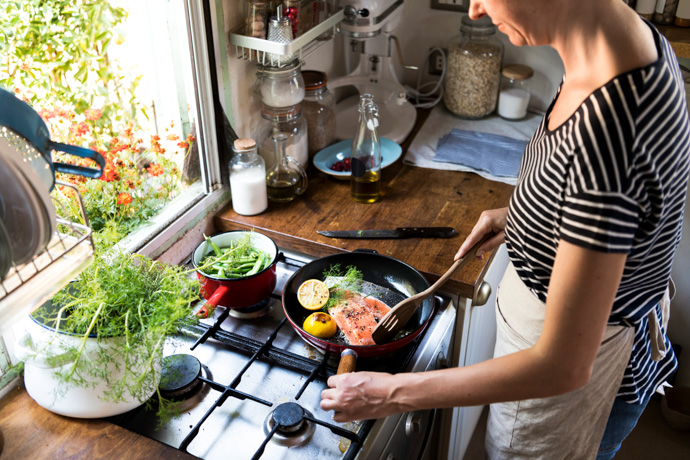 Mujer cocinando salmón