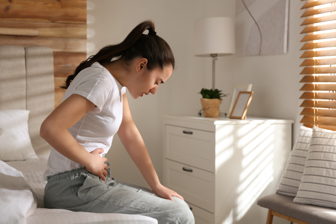 mujer sentada con dolor de tripa