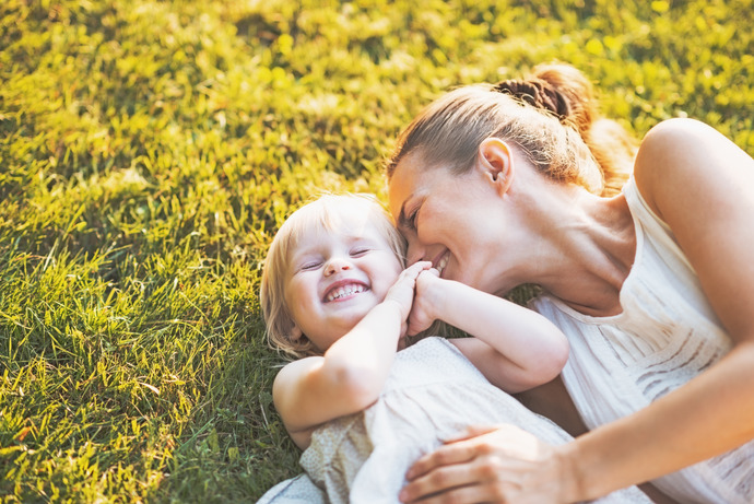 Mujer feliz disfrutando la vida con su hija al tener una mente positiva.