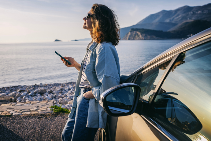 Mujer tomando un deescanso cerca de la playa en su carro