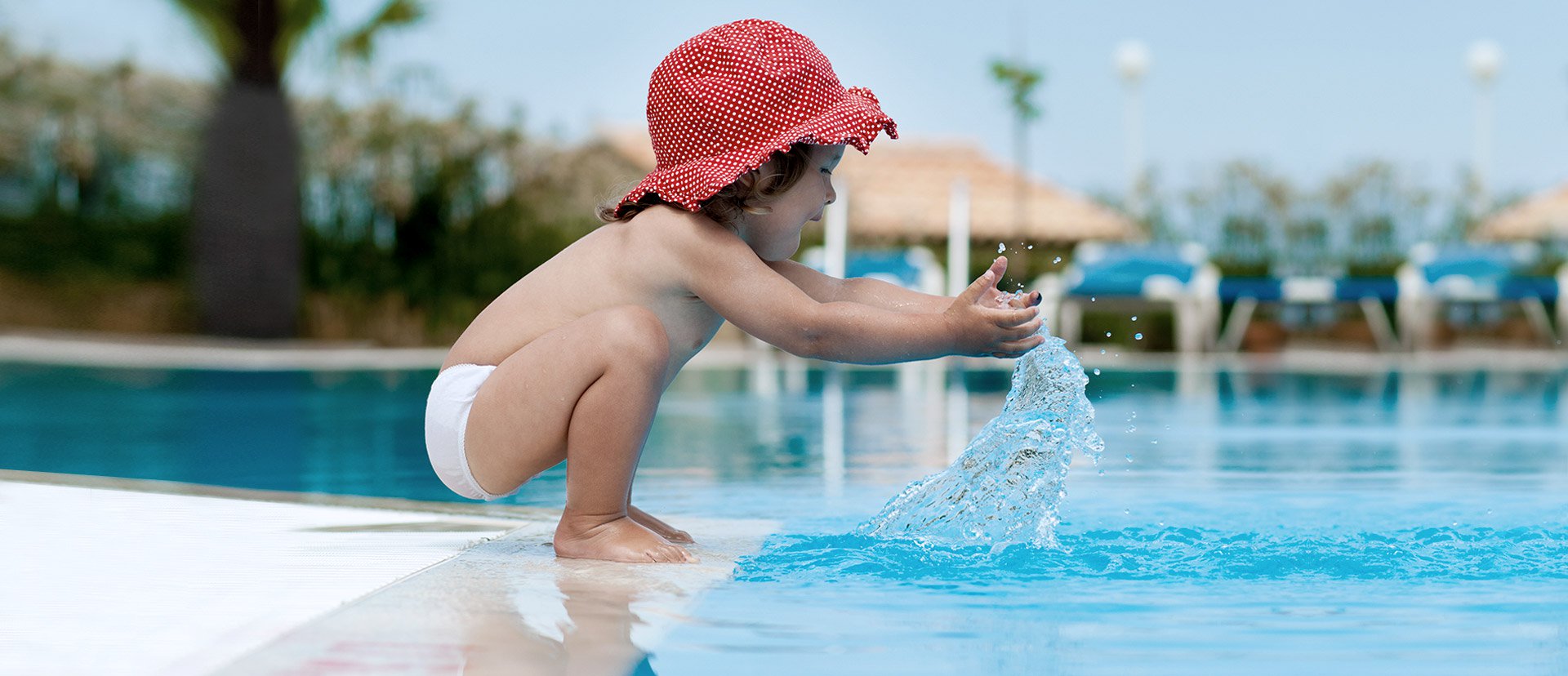 Niña jugando con el agua en la piscina