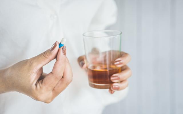 Mujer tomando antibióticos con alcohol.