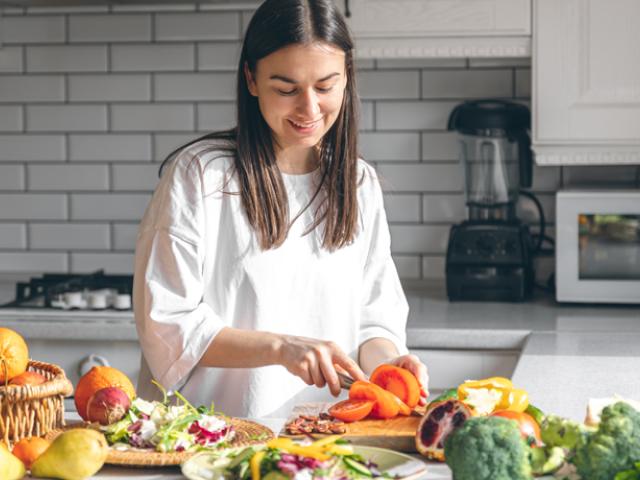 Mujer cortando vegetales en la cocina